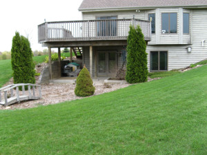 Before construction: The deck has two posts in the middle of the existing lower patio. The left hand side of the patio features a failing timber retaining wall that bears directly on the deck posts causing potential structural hazards. The plantings are limited and uninspired creating no sense of place. The ultimate design overcame these limitations.