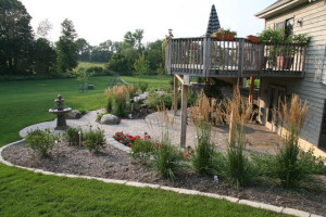 The landscape layout creates a connection between the deck and the patio. Planters are integrated in the deck railing to visually connect the deck environment to the main planting beds. To reduce maintenance, lannon edger stones were used to contain the planting beds thereby eliminating the need to trim the lawn at the bed edge. The overall composition of the landscape blends seamlessly with the remainder of the site.